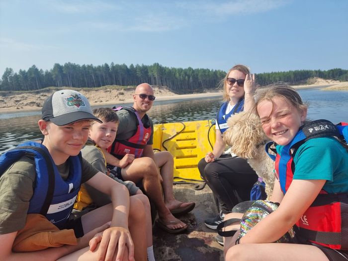 A family and their dog landed on the beach beside the water taxi
