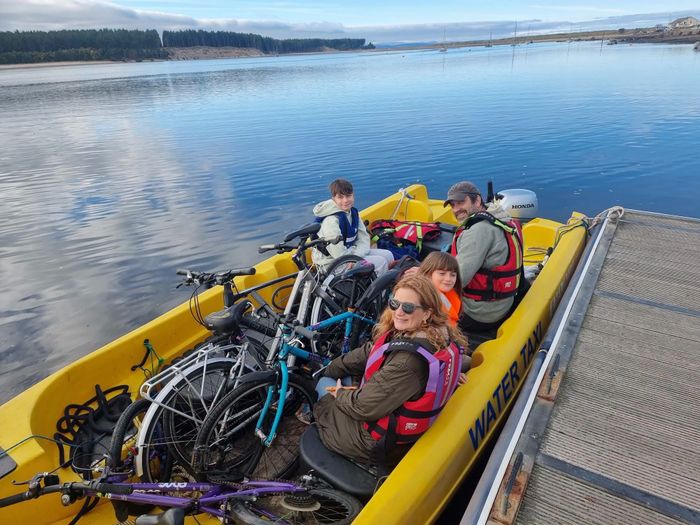 Passengers and their bikes aboard the water taxi at the Findhorn pontoon