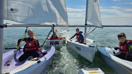 Young sailors rafted together in training dinghies
